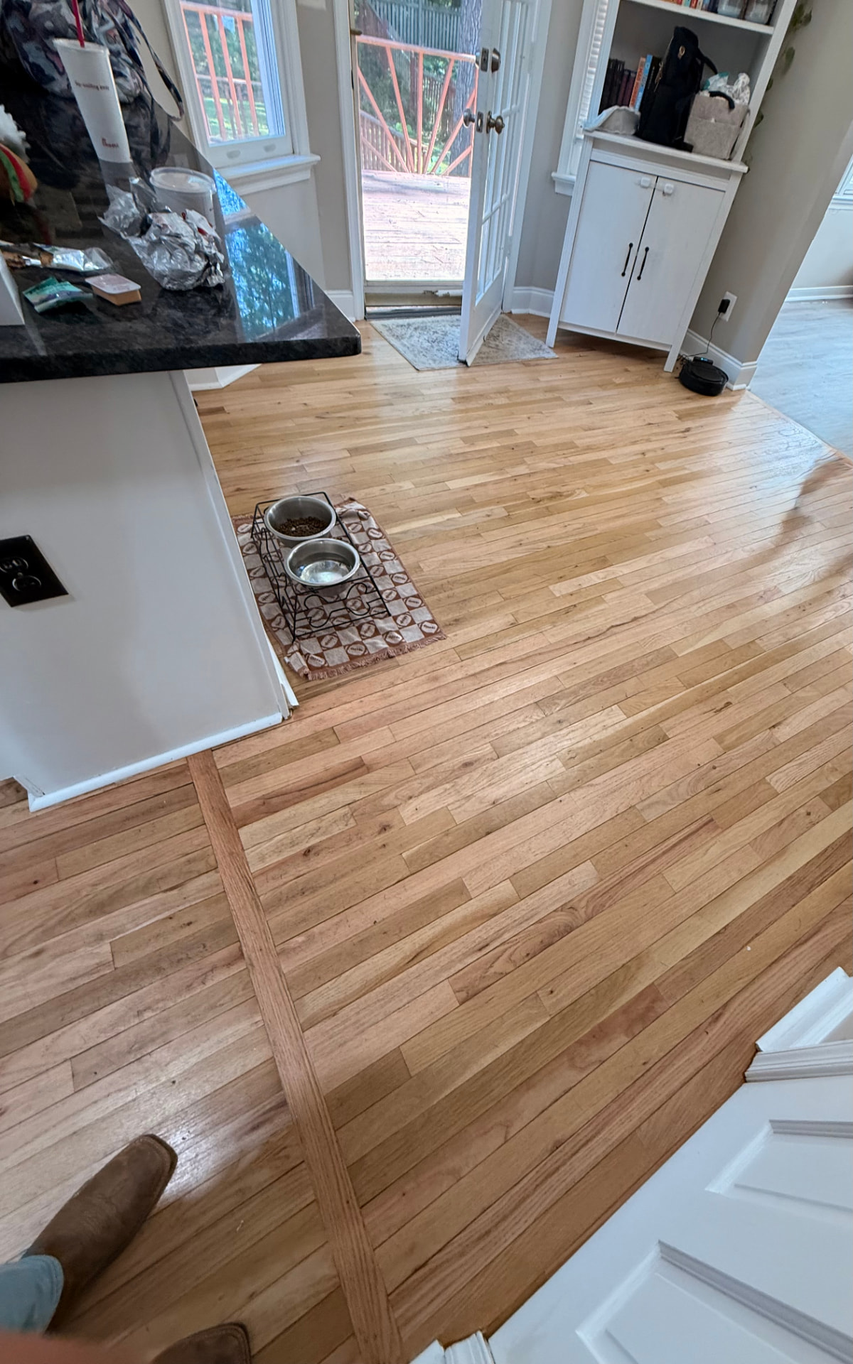 Existing hardwood flooring in a kitchen before replacement