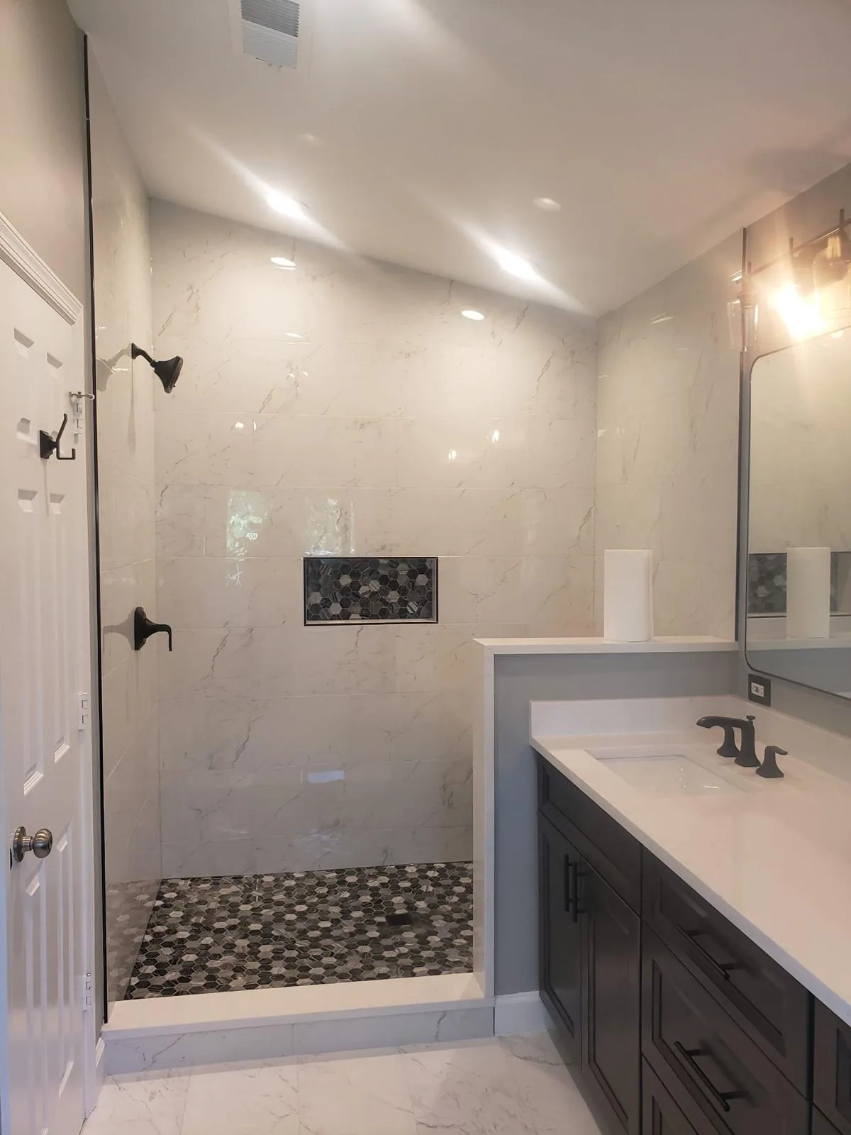 Walk-in shower with marble tile and hex mosaic floor, luxury bathroom remodel Richmond VA