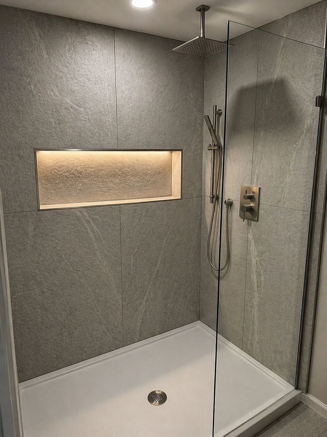 Modern walk-in shower with gray stone tile and lit niche, Richmond VA bathroom remodel